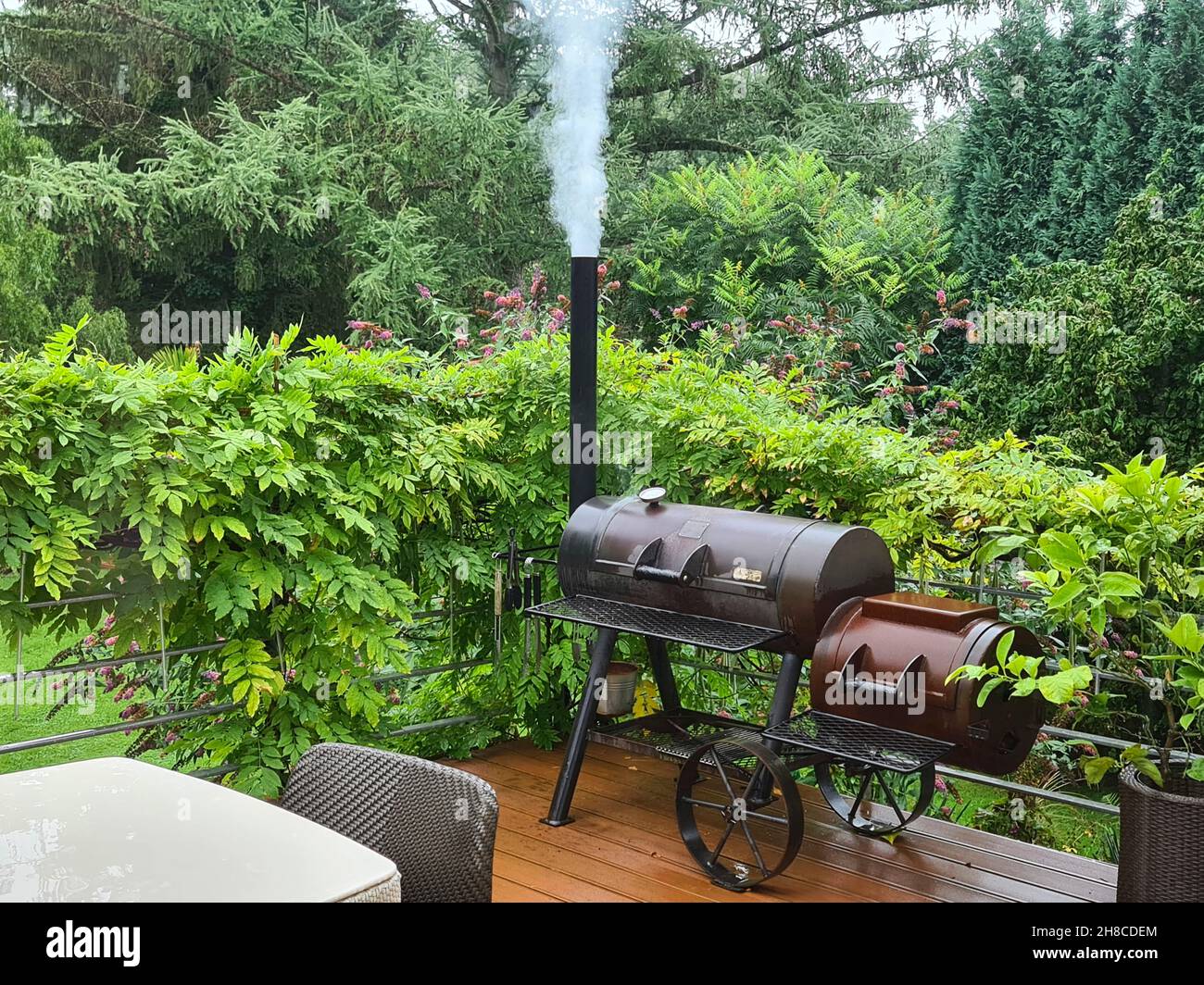 smoking barbecue smoker on a terrace, Germany Stock Photo