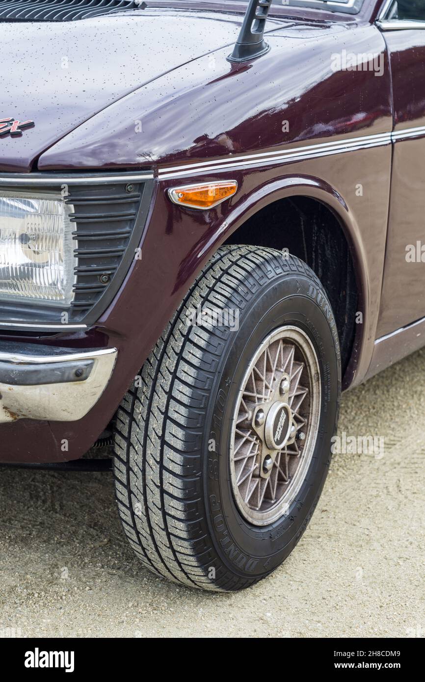 Close up detail of the front wheel on a dark purple brown Suzuki Fronte