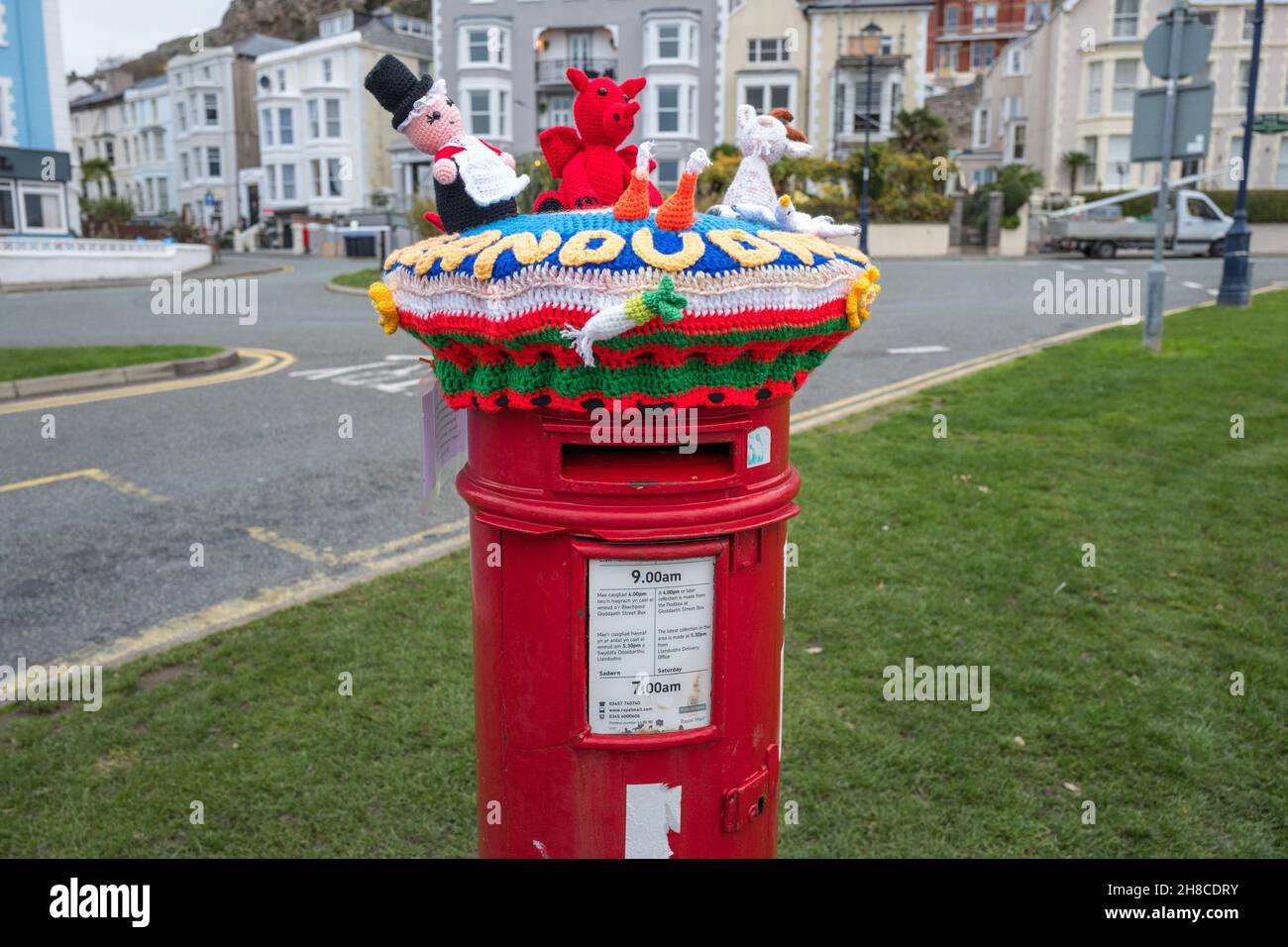 Red letter box decorated with knitted welsh characters, llandudno, Wales. Stock Photo