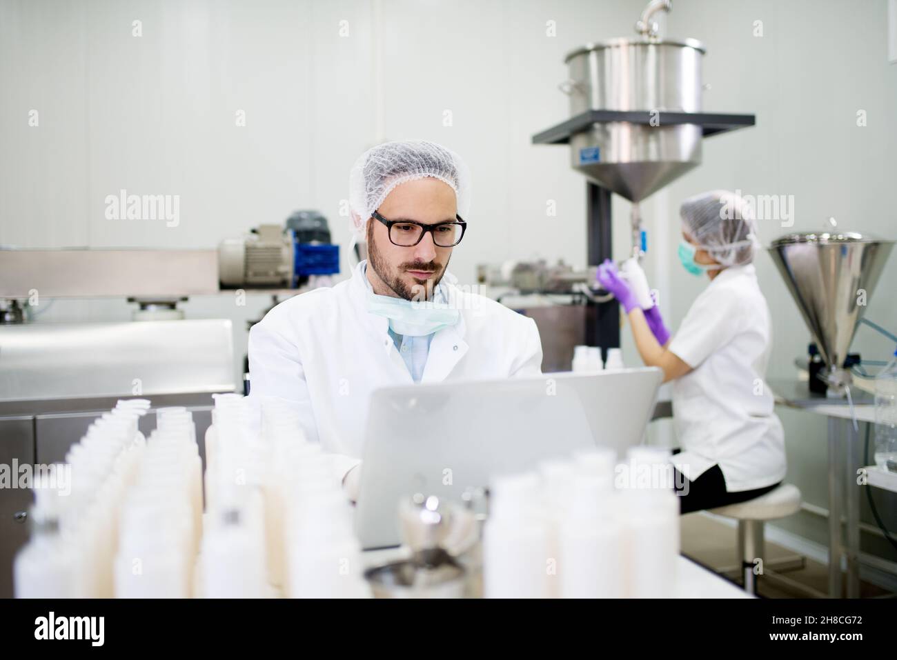 Cosmetic Operating Machine Technologist and machine operator working in cosmetic products factory ...