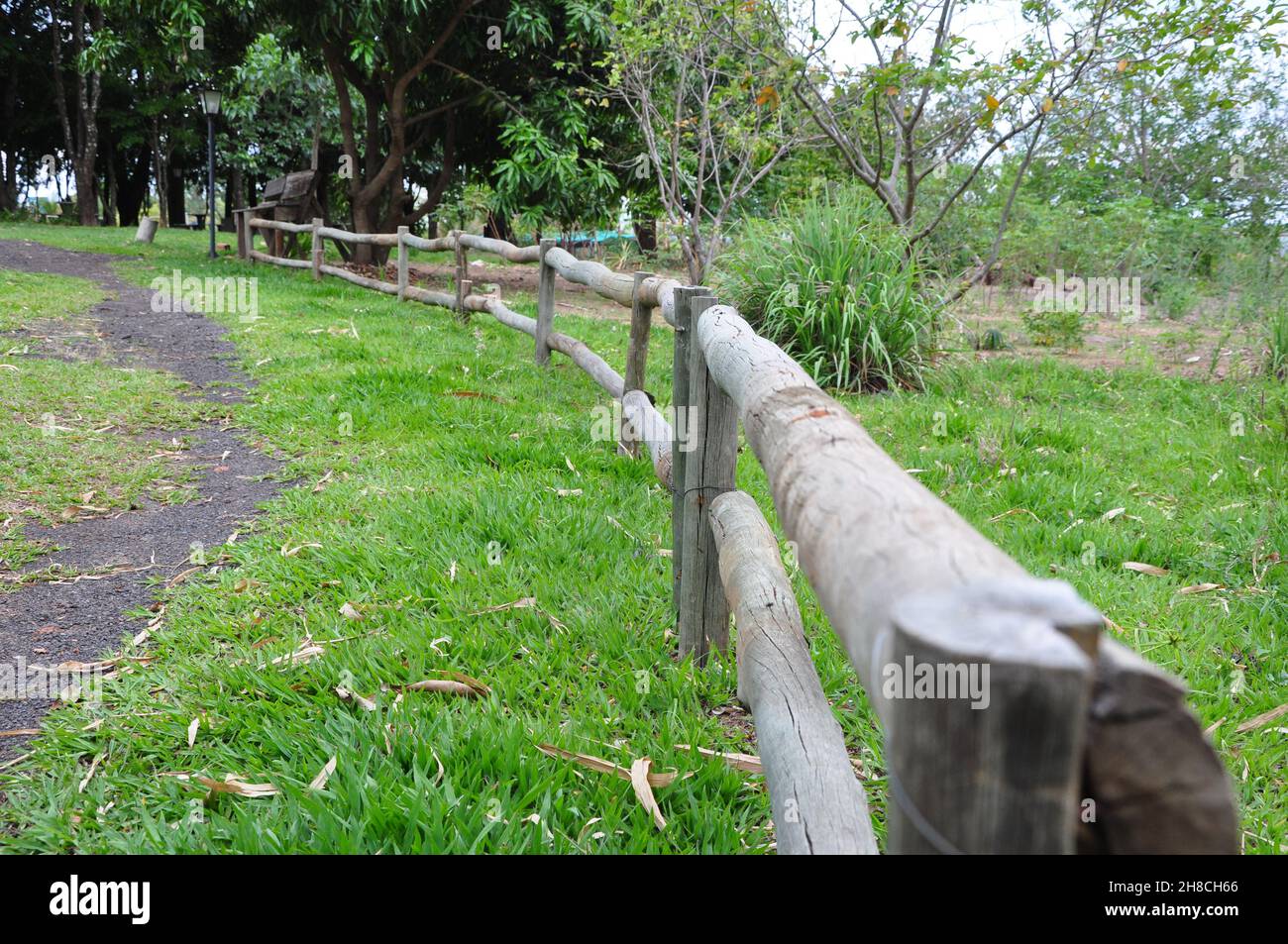 Wooden fence in panoramic view with out of focus foreground and green area with path on the side in a tourist site in the interior of Brazil, South Am Stock Photo