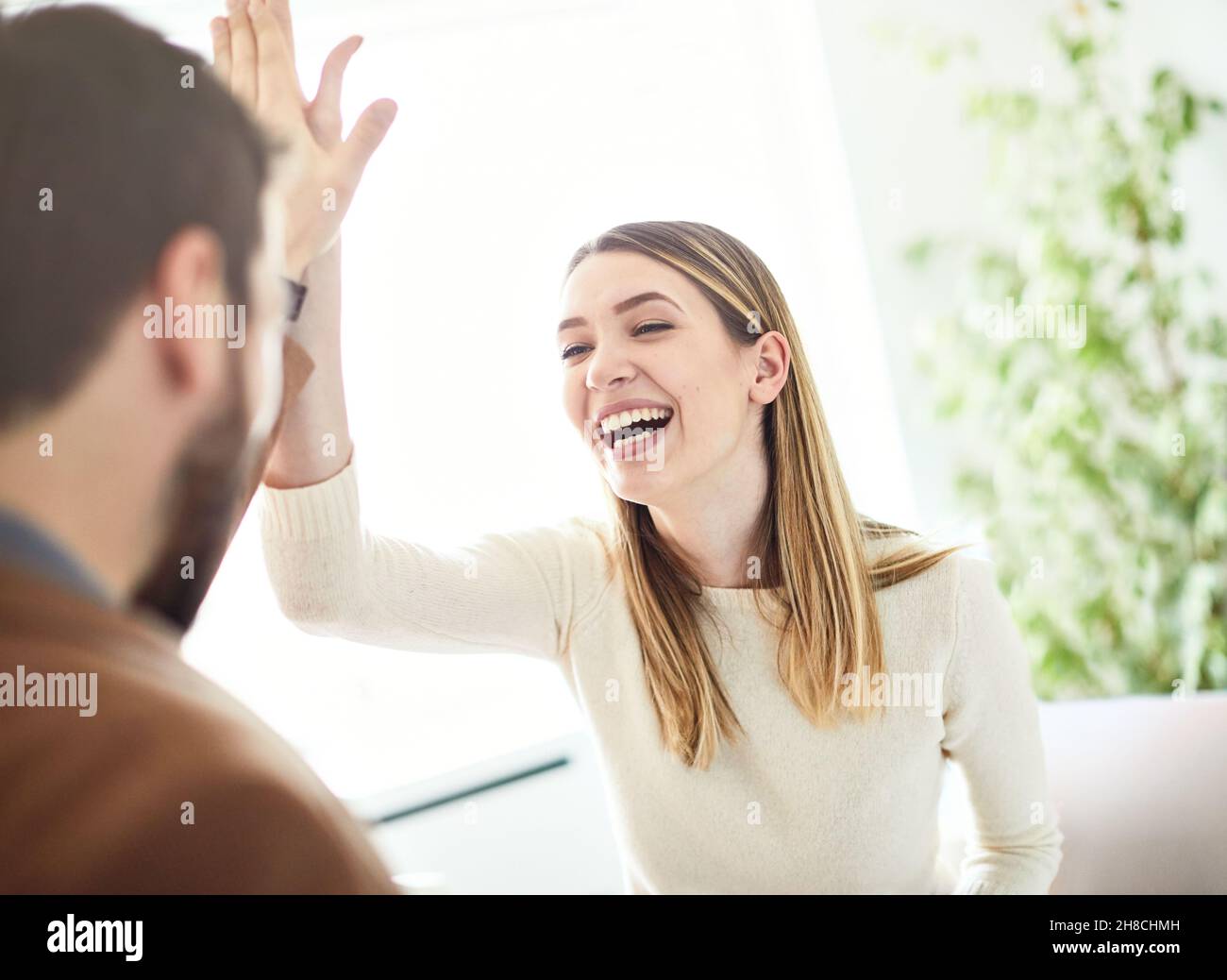 Colleagues Giving High-Five Celebrating Business Success Standing In Office  Stock Photo by ©Milkos 381522740