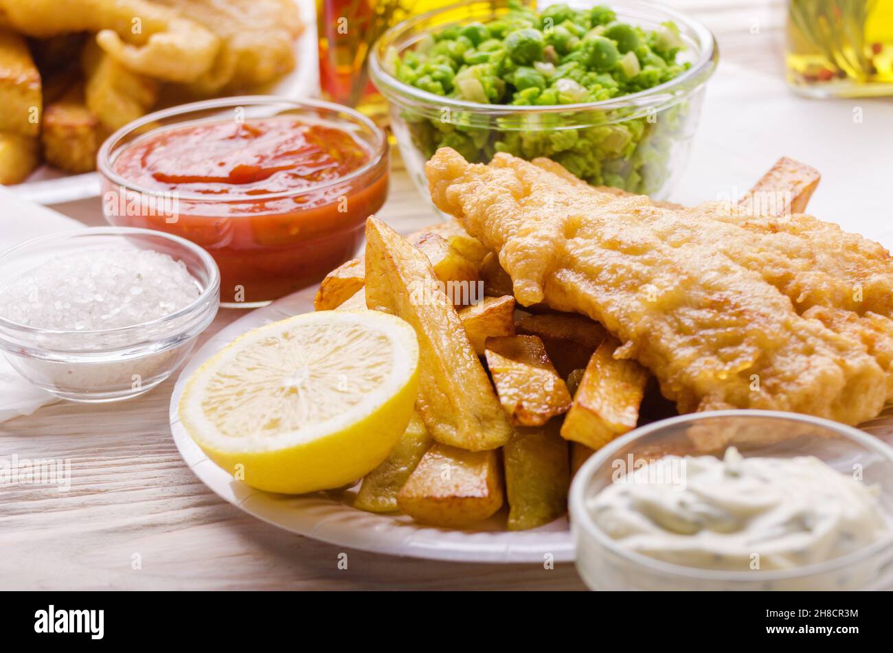 Traditional British street food fish and chips with ketchup and tartar