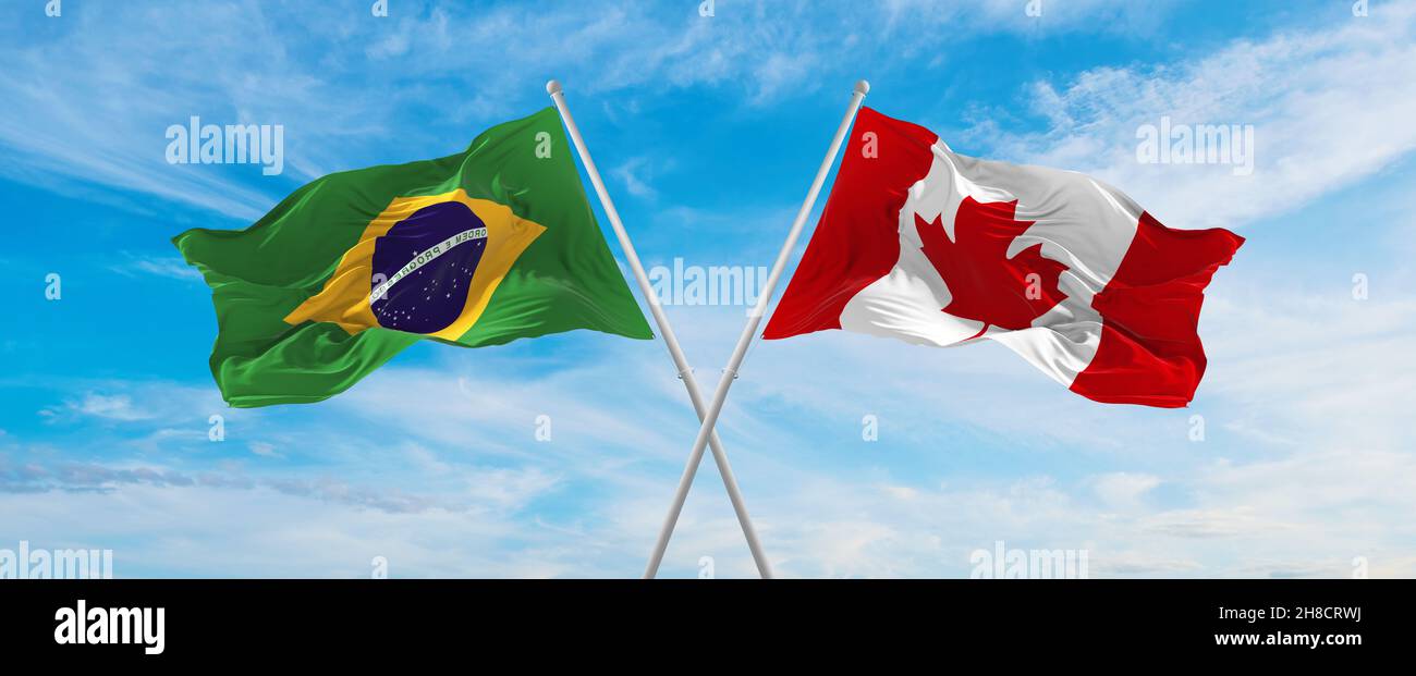 crossed national flags of Brazil and canada flag waving in the wind at ...