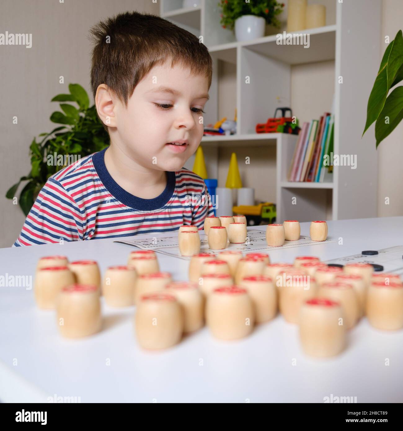 A 4yearold boy plays loto, studies numbers using a board game Stock