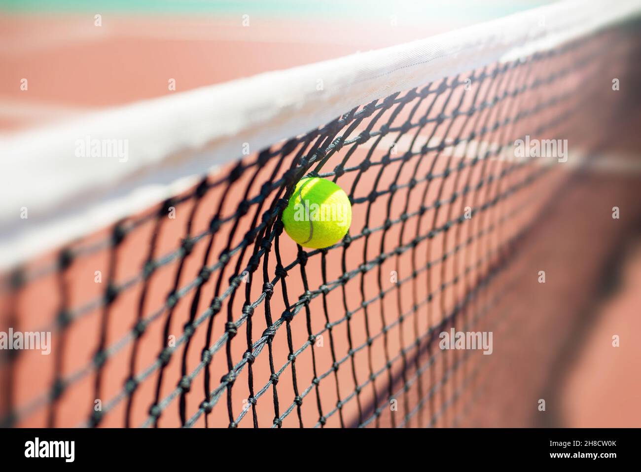 Tennis ball hits in the net during game. Stock Photo