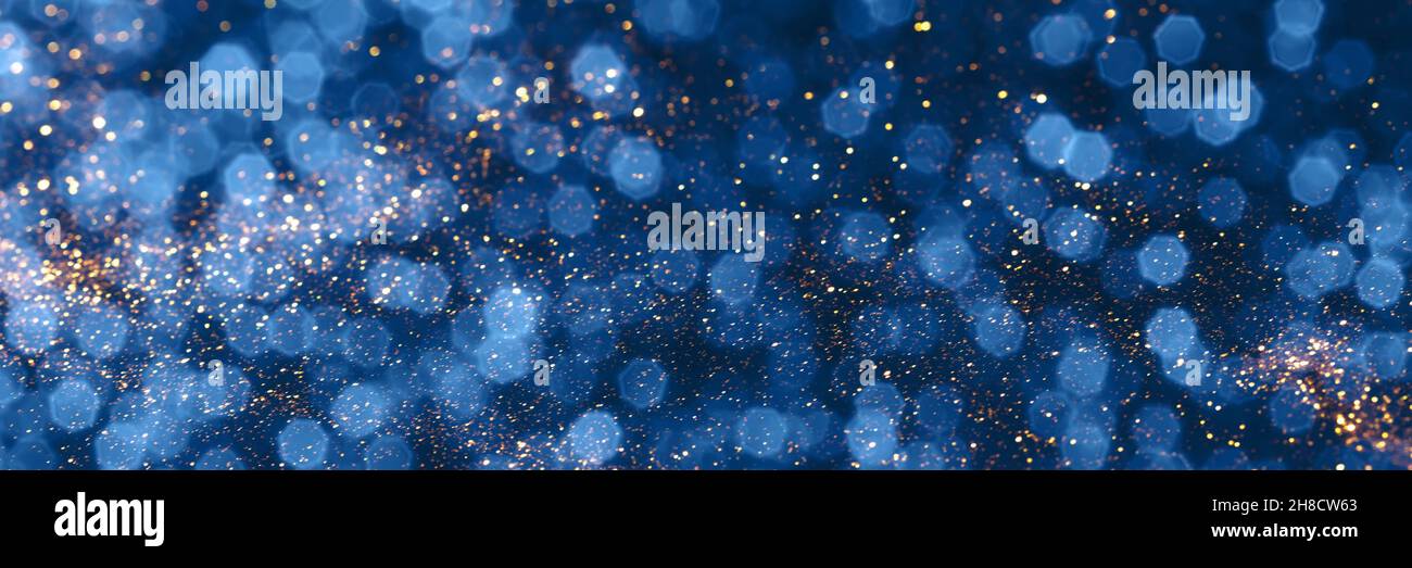 Blue and golden sparkling glitter bokeh background, christmas texture. Holiday lights. Abstract defocused header. Wide screen wallpaper Stock Photo