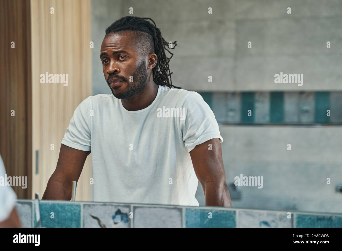 Concentrated man looking at his face in bathroom Stock Photo