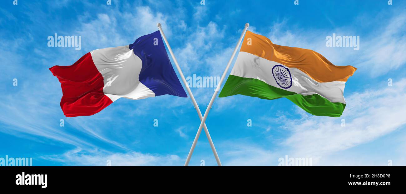 crossed national flags of France and India flag waving in the wind at ...