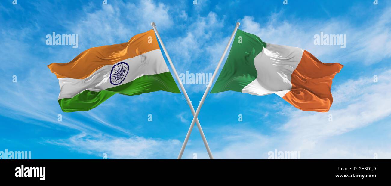 crossed national flags of India and Ireland flag waving in the wind at cloudy sky. Symbolizing