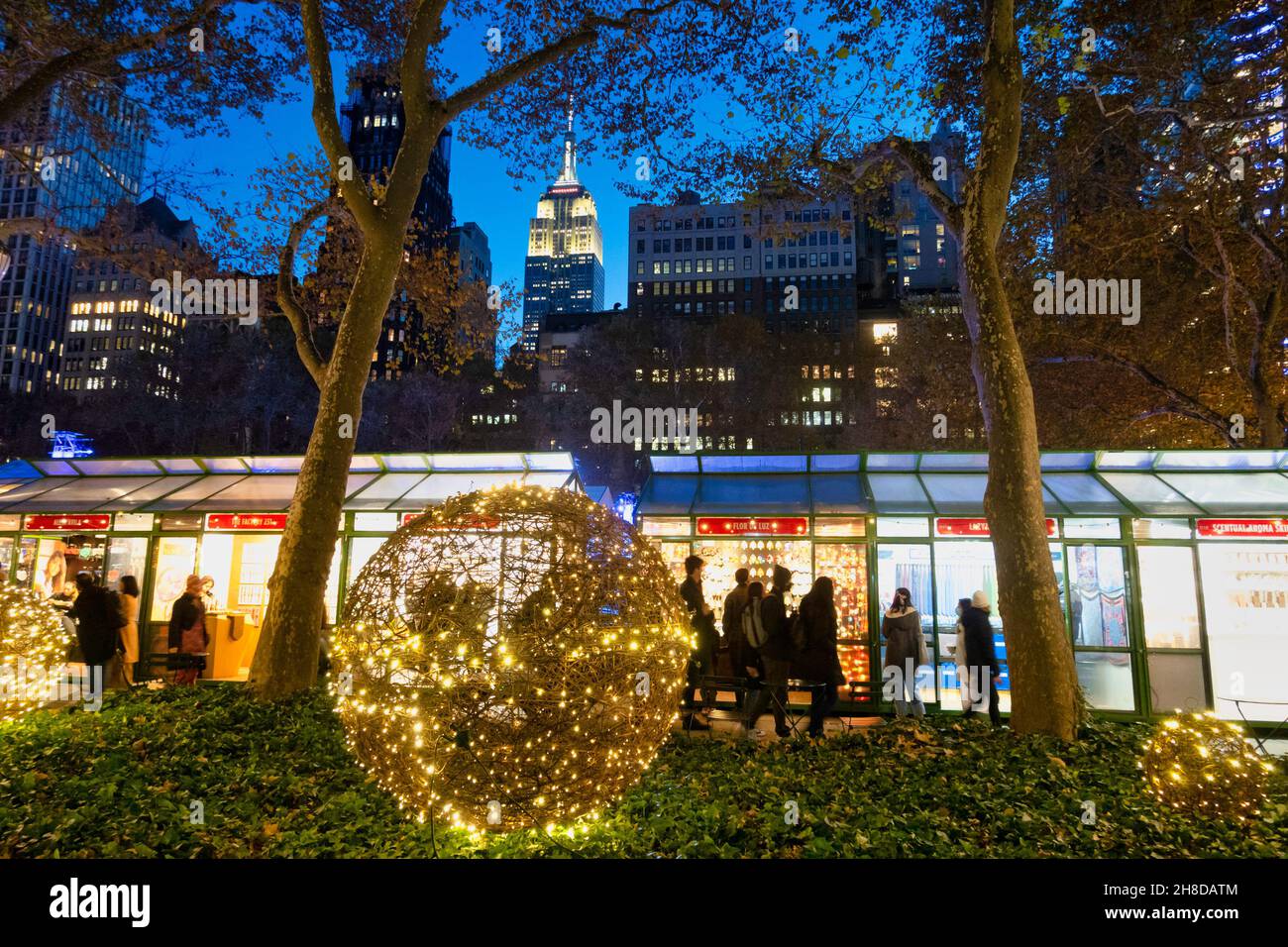 Bank of America Winter Village at Bryant Park with the Empire State Building looming in the background, New York City, USA Stock Photo