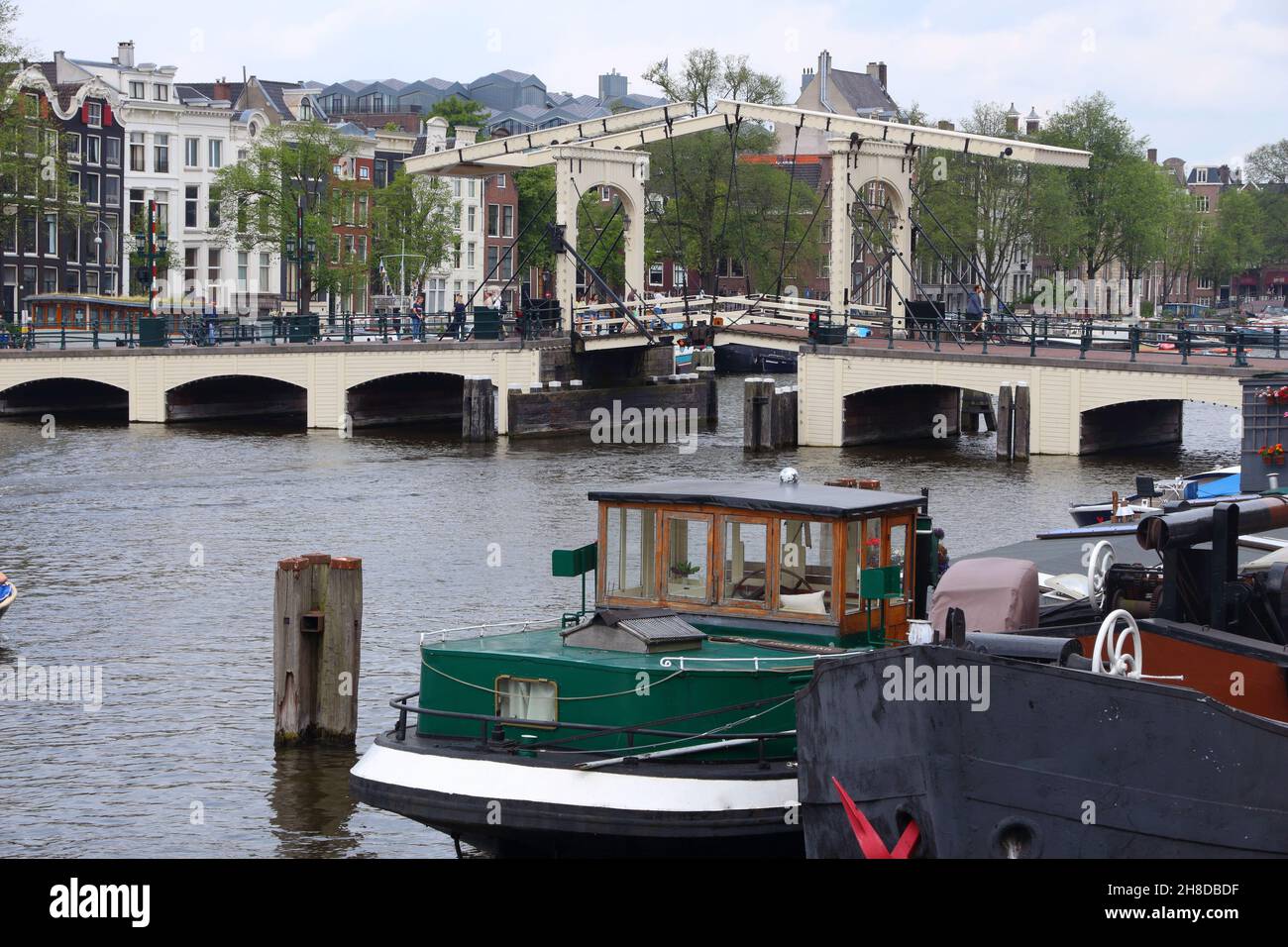 AMSTERDAM, NETHERLANDS - JULY 8, 2017: People visit Magere Brug (The Skinny Bridge) in Amsterdam, Netherlands. Amsterdam is the capital city of The Ne Stock Photo