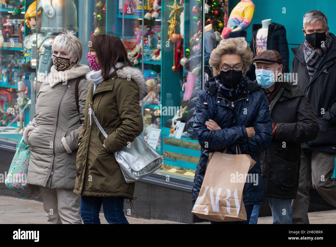 Windsor, UK. 29th November, 2021. Shoppers wear face coverings as they leave a department store. The Health Secretary Sajid Javid yesterday announced following the emergence in the UK of the Omicron coronavirus variant that the wearing of face masks would become mandatory in shops and on public transport with effect from 4am on 30th November, with fines ranging between £200-£6,400 to be issued to people in England who fail to wear them depending on the number of offences. Credit: Mark Kerrison/Alamy Live News Stock Photo