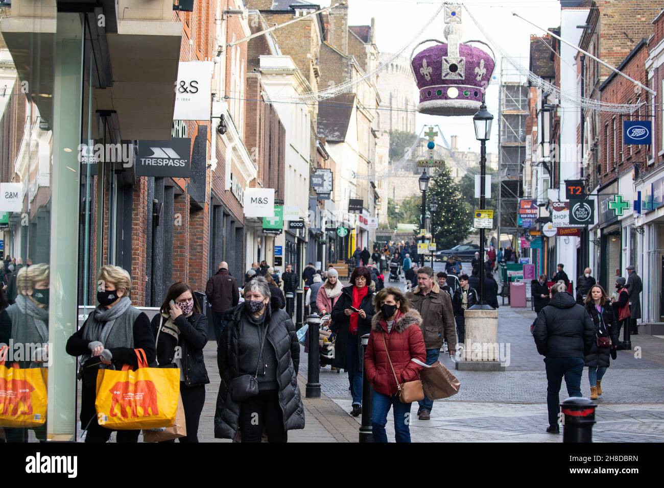 Windsor, UK. 29th November, 2021. Shoppers pass through the town centre, many wearing face coverings. The Health Secretary Sajid Javid yesterday announced following the emergence in the UK of the Omicron coronavirus variant that the wearing of face masks would become mandatory in shops and on public transport with effect from 4am on 30th November, with fines ranging between £200-£6,400 to be issued to people in England who fail to wear them depending on the number of offences. Credit: Mark Kerrison/Alamy Live News Stock Photo