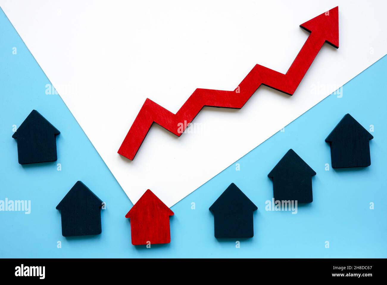 Small houses and an arrow symbolizing the rise in property prices. Real estate value. Stock Photo