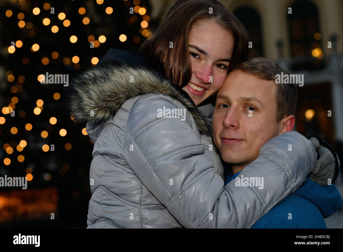 A young couple in love hugs at the Christmas market. Stock Photo