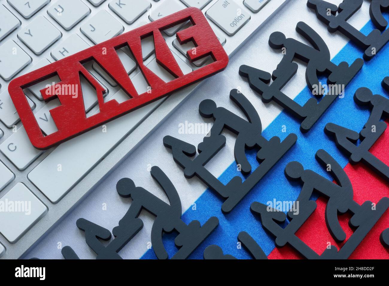 Fake news and troll factory. Figures at the computer on the Russian flag. Stock Photo
