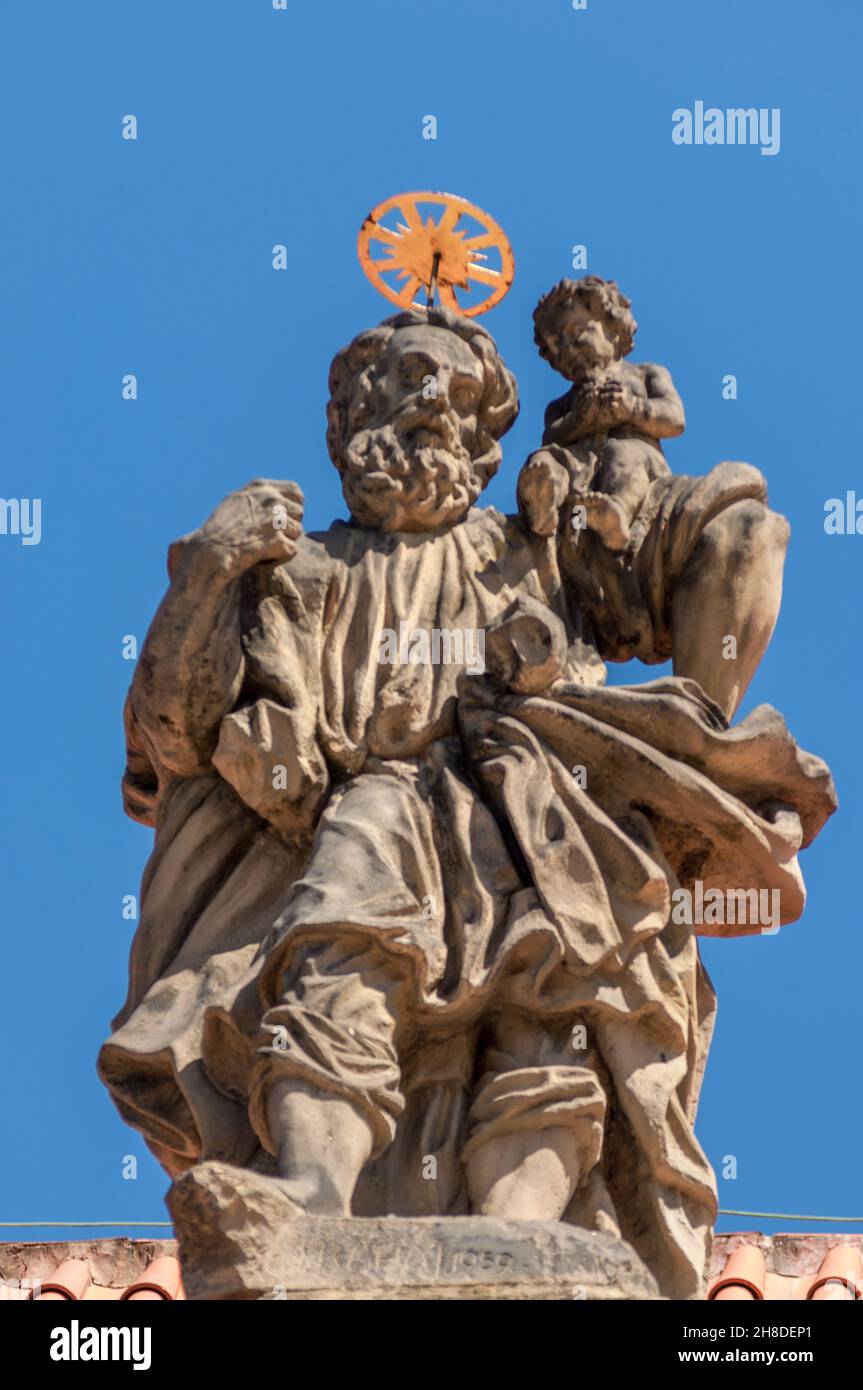 The Statue of Saint Christopher carrying a child, on the facade of the Prague Loreto. Stock Photo