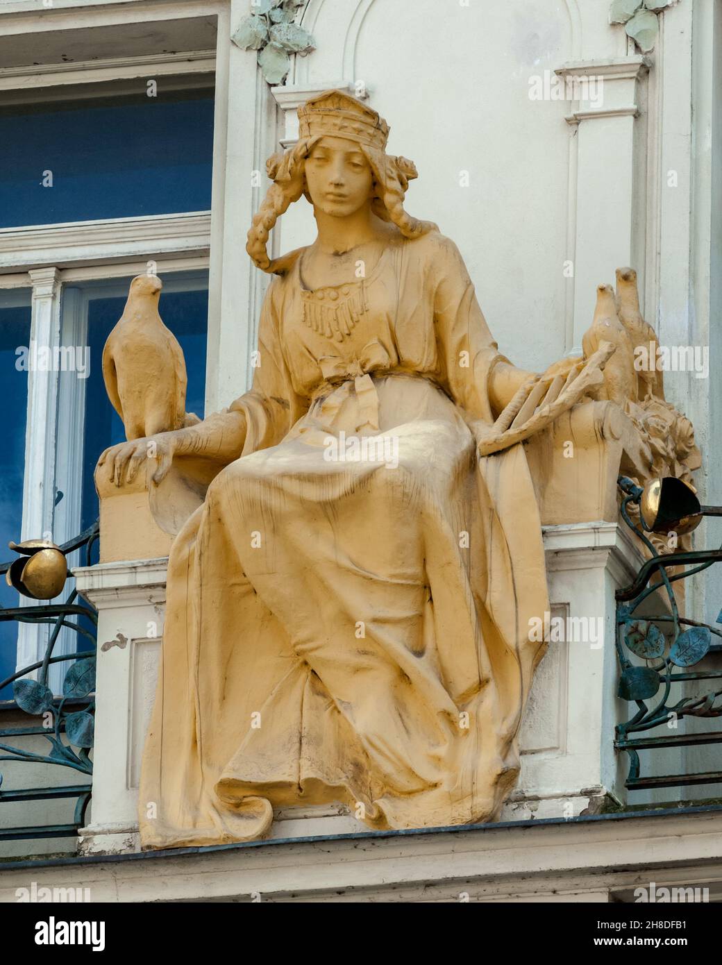 A sculpture of a girl with a harp and doves sits on the balcony of Osvald Polívka's Art Nouveau facade of 178 Karlova Street in Prague's Old Town. Stock Photo