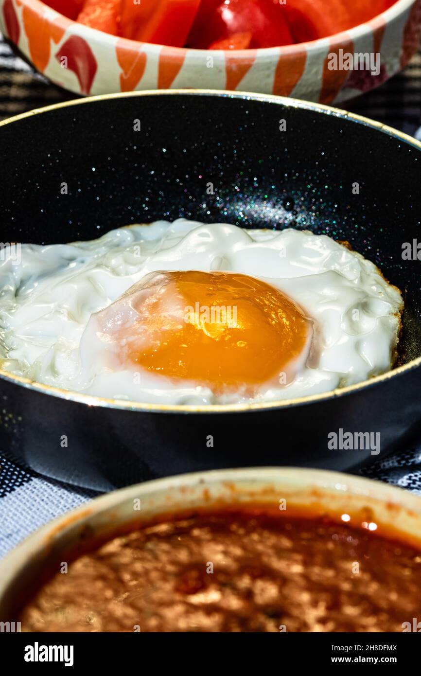 Close up of fried egg in a small frying pan isolated in a rustic ...