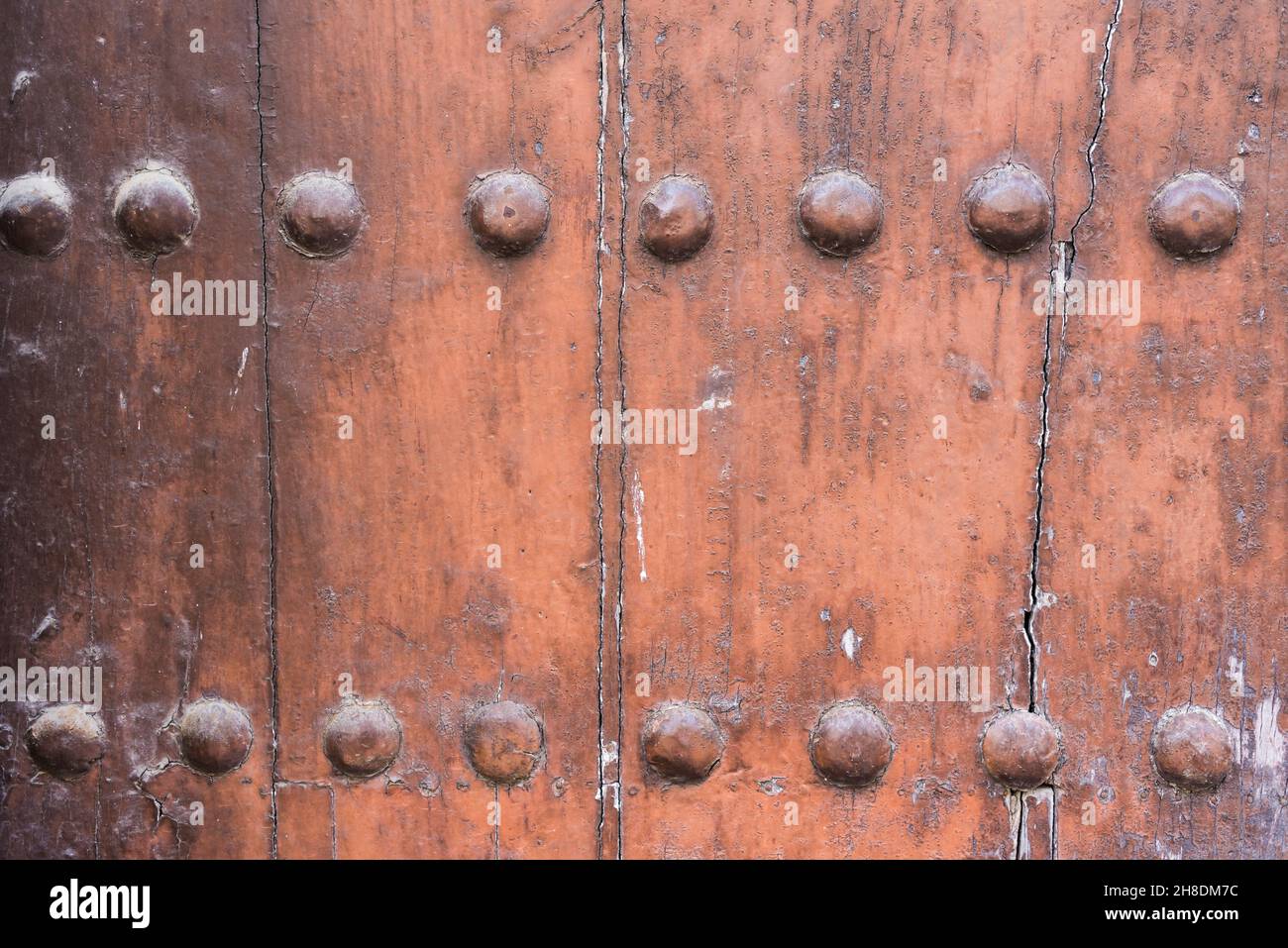 Textured background of a brown wooden door with nails. Copy space. Stock Photo