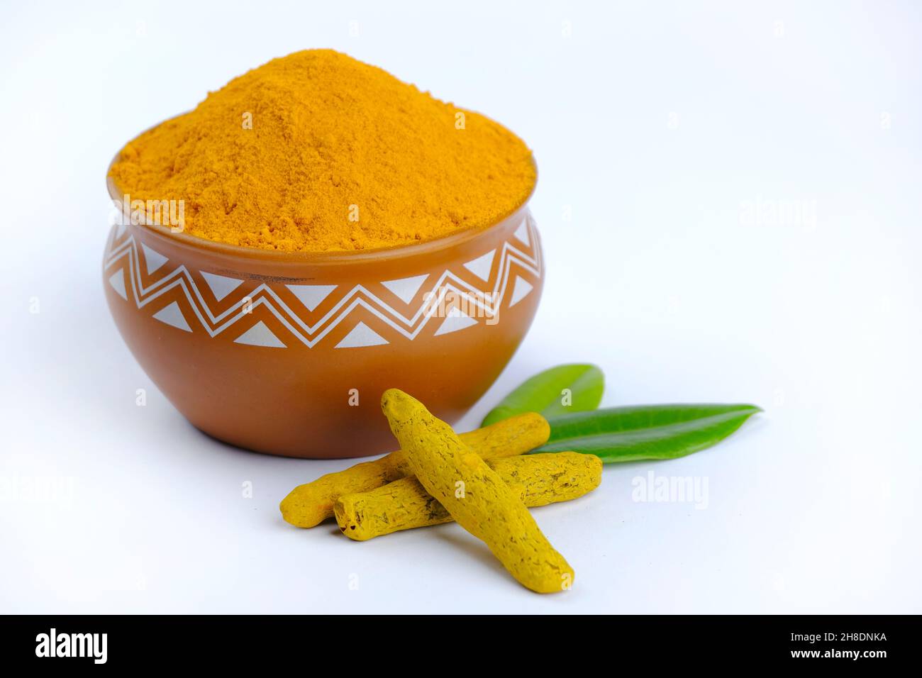 Turmeric Powder, Tumeric rhizome and turmeric powder in bowl isolated