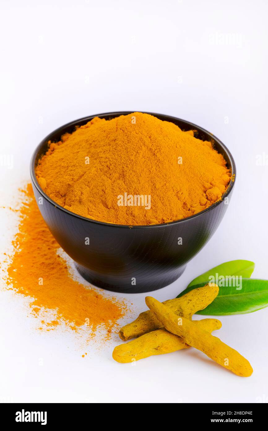 Turmeric Powder, Tumeric rhizome and turmeric powder in bowl isolated