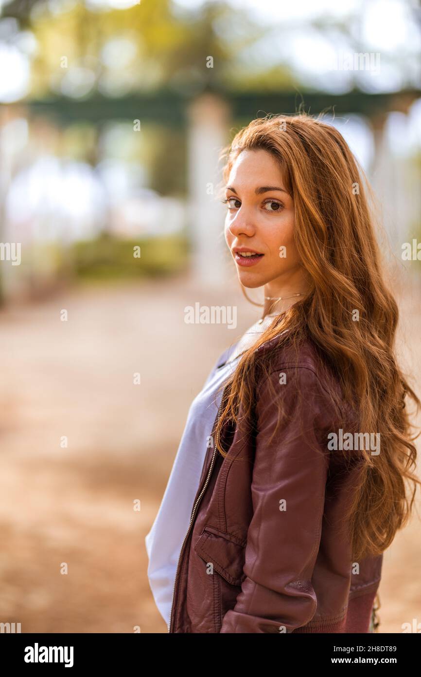Young natural girl turning towards camera in casual dress in the park Stock Photo