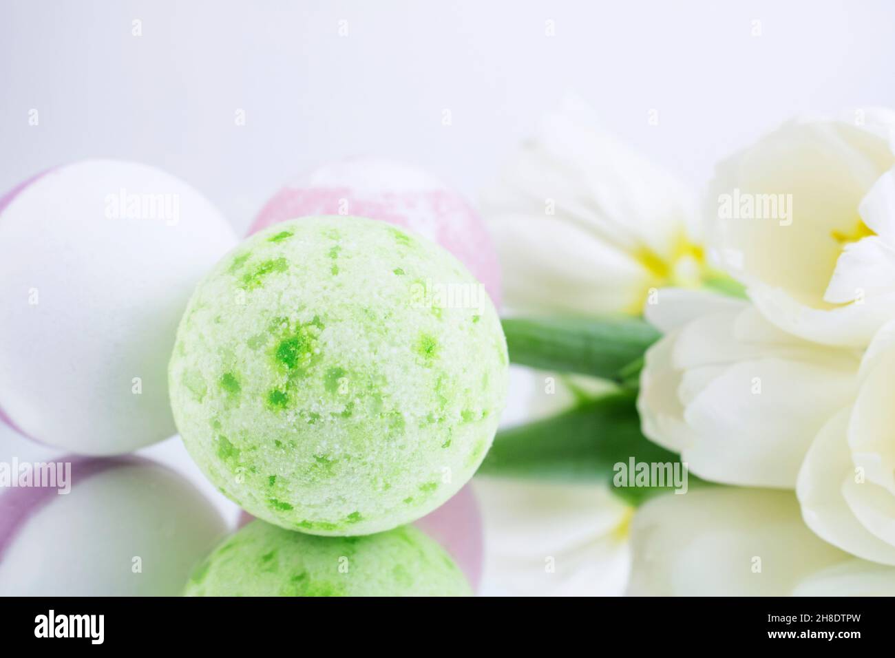 A green and pink salt bomb on a white gray background is reflected