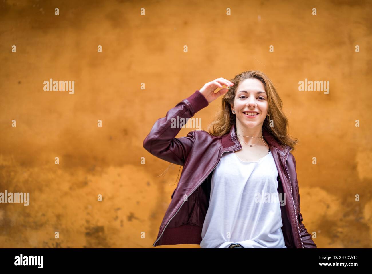 Young and happy girl in casual clothes enjoying on orange background Stock Photo