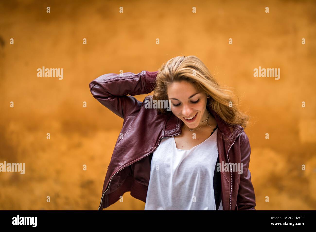 Young and happy girl in casual clothes enjoying on orange background close up Stock Photo
