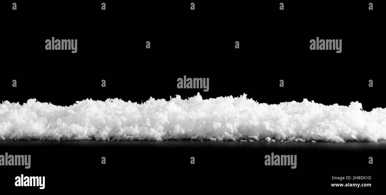 Close white snow isolated on black background Stock Photo