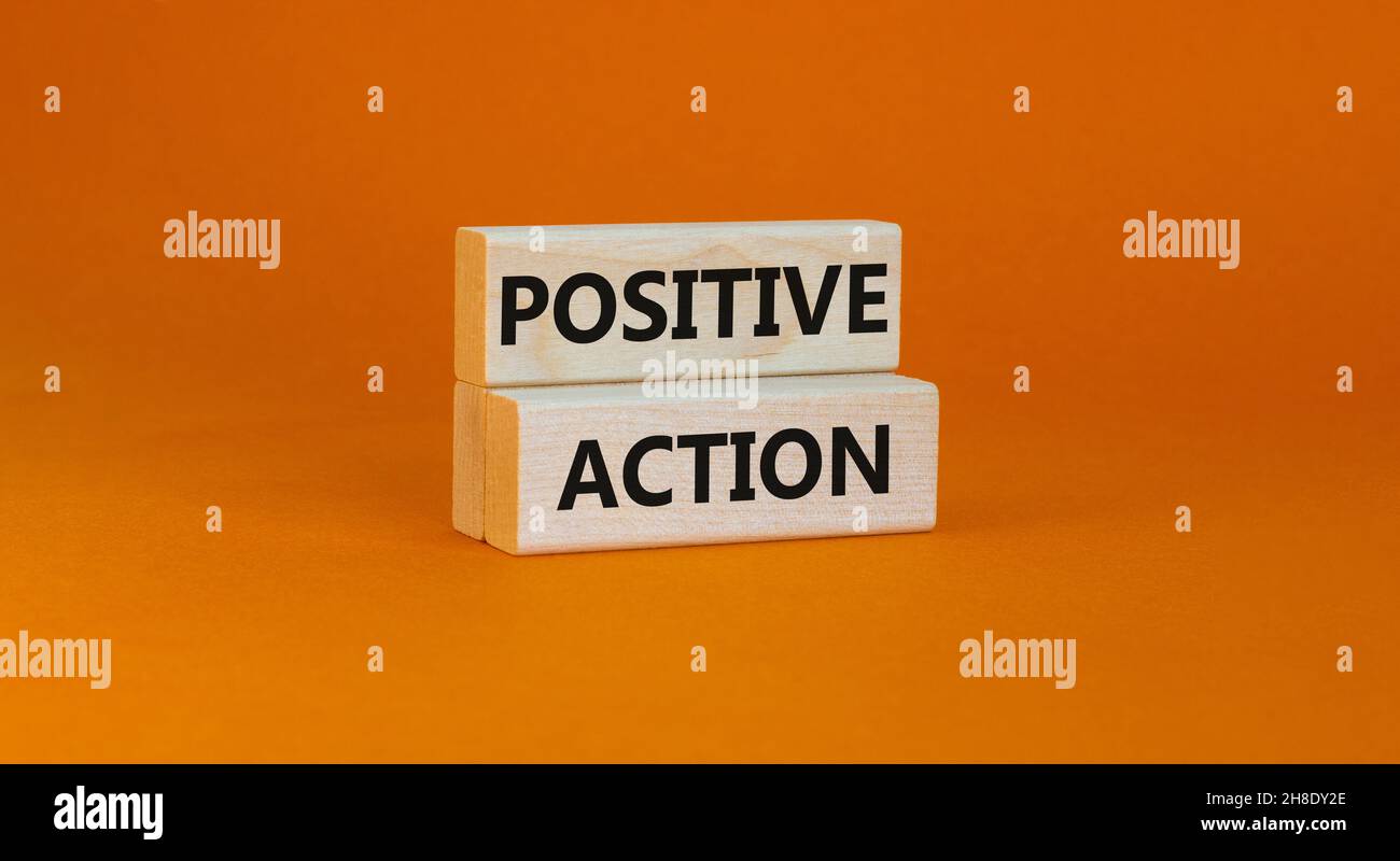 Time to positive action symbol. Wooden blocks with concept words 'Positive action'. Beautiful orange background. Business and positive action concept. Stock Photo