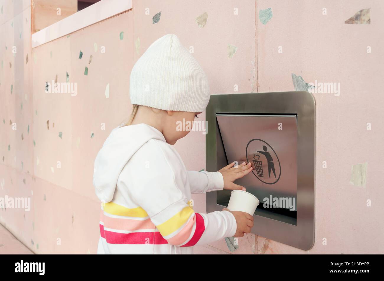 Child throwing paper cardboard cup away into sorting recycling can. Educative photo of awareness. Sorting and recycling. Garbage separation Stock Photo