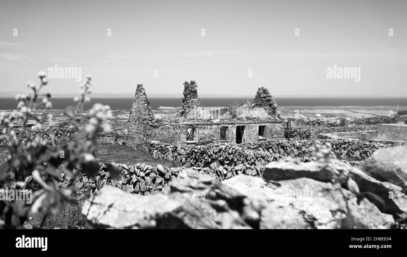 Black and white shot of a ruined, abandoned cottage on Inishmaan (Inis Meain), one of the Aran Islands off the coast of Galway in the west of Ireland. Stock Photo