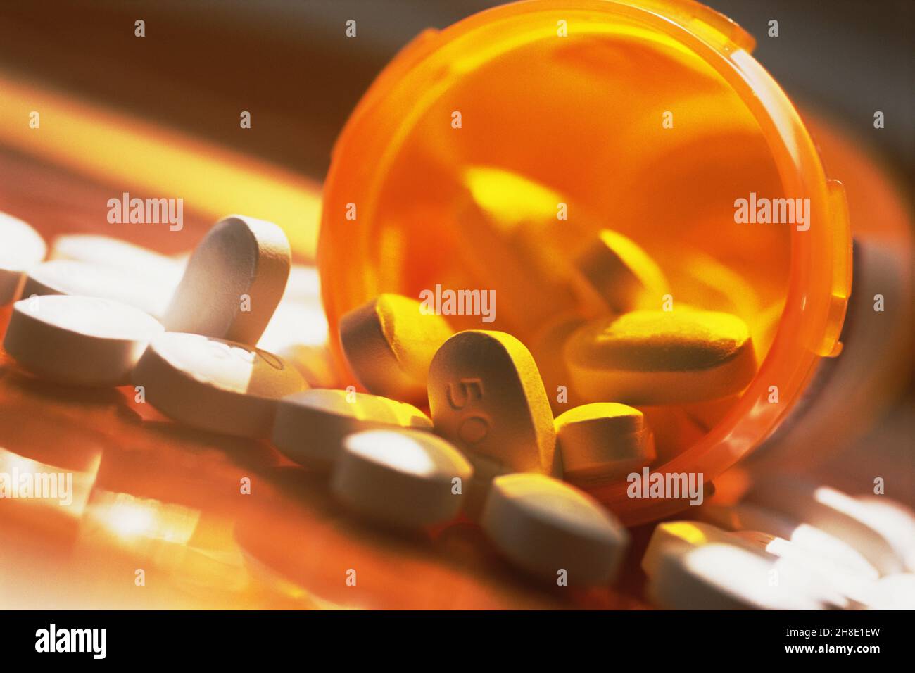Pills spilling open container or bottle. Drugs, cure. Healthcare prescribed treatment medication for illness or pain. Drug addiction prescription. Stock Photo