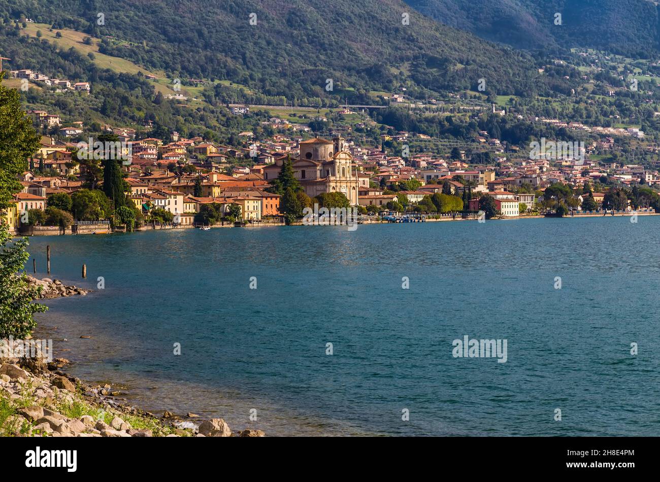 Lake Iseo and a small town on its birch with an ancient church in the center. Sale Marazino. Italy Stock Photo