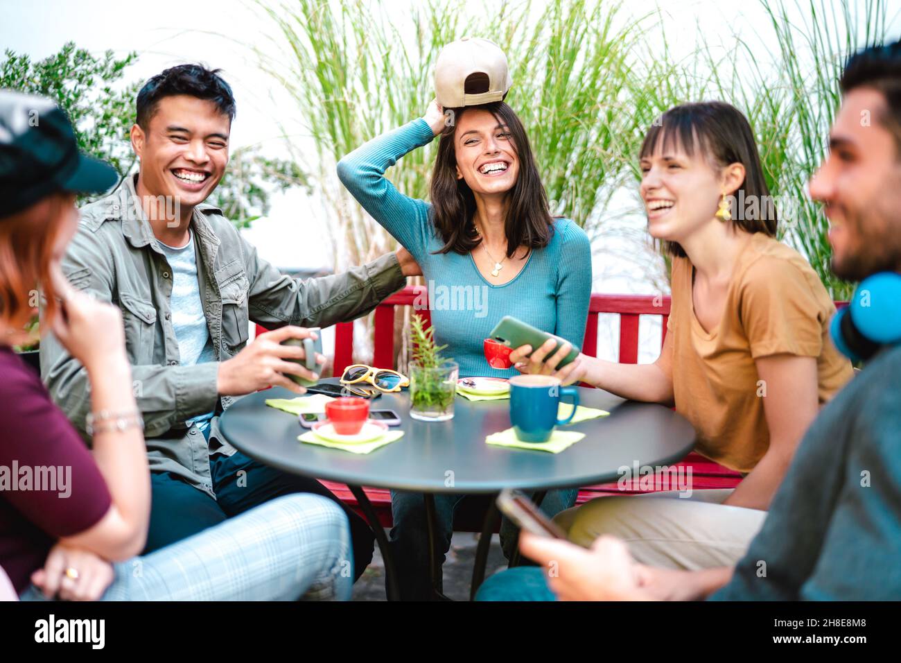 Multicultural group drinking latte at coffee bar restaurant - Happy friend talking and having fun together at hostel dehors - Life style concept Stock Photo