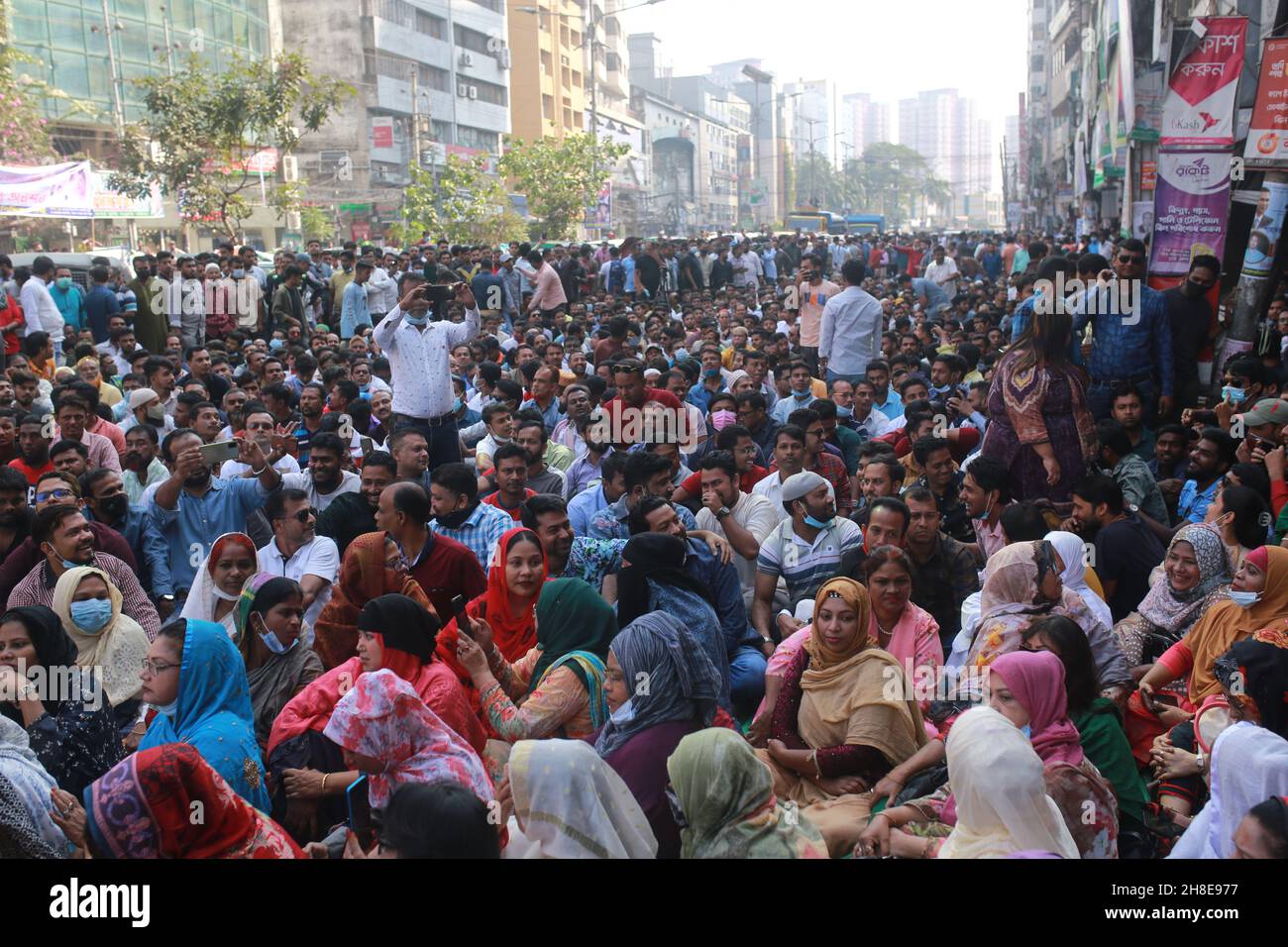 Activists of the Bangladesh Nationalist Party (BNP) sit on road during Bangladesh Nationalist Party’s protest rally demanding the government to allow party's chairperson Begum Khaleda Zia to be allowed international travel for better health treatment in Dhaka, Bangladesh. Stock Photo