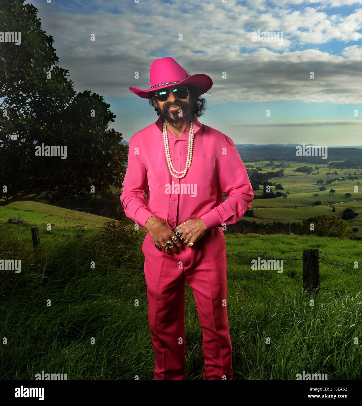 Byron Bay's Shanti Ananda maybe the best dressed homeless person in the world. Known locally as 'The Pink Cowboy' he stands alone high on the volcanic Stock Photo