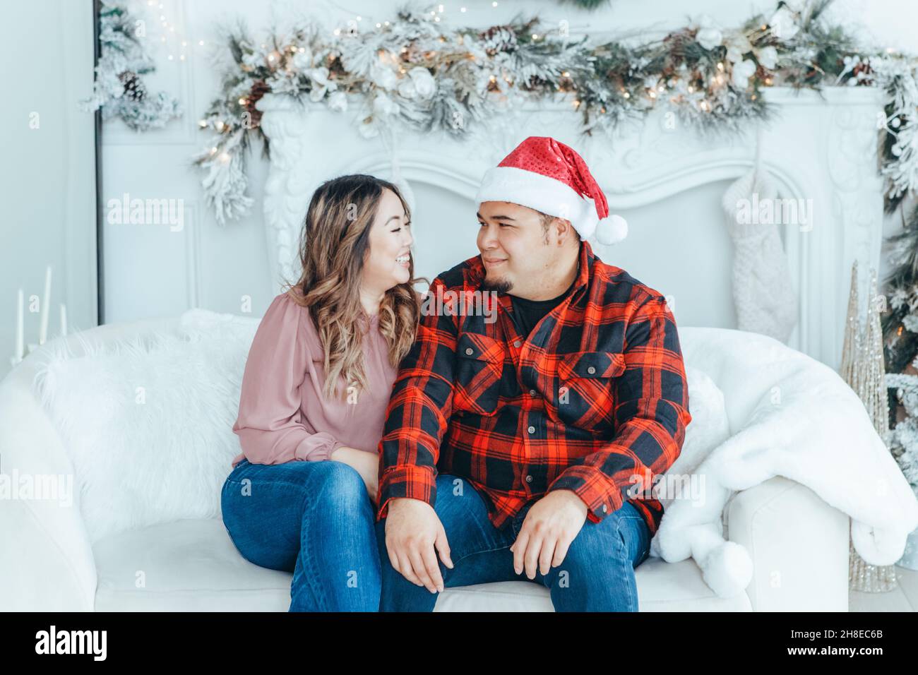 Asian couple in love man and woman celebrating Christmas or New Year winter holiday at home together. Married couple husband and wife or boyfriend and Stock Photo