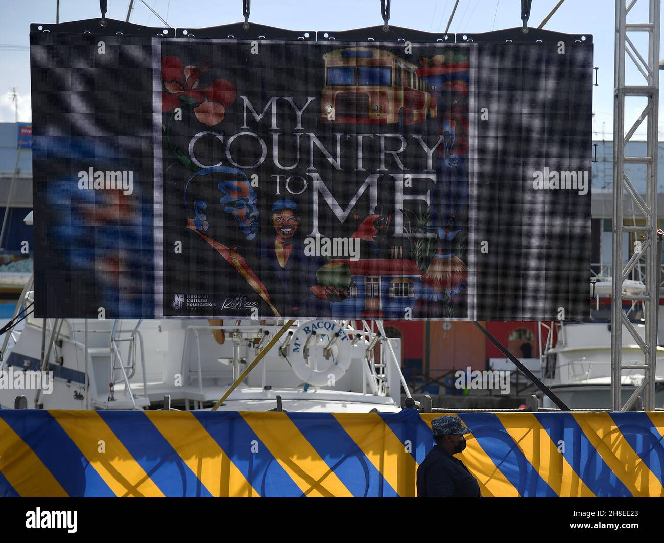 A security guard stands by an electronic screen in National Heroes
