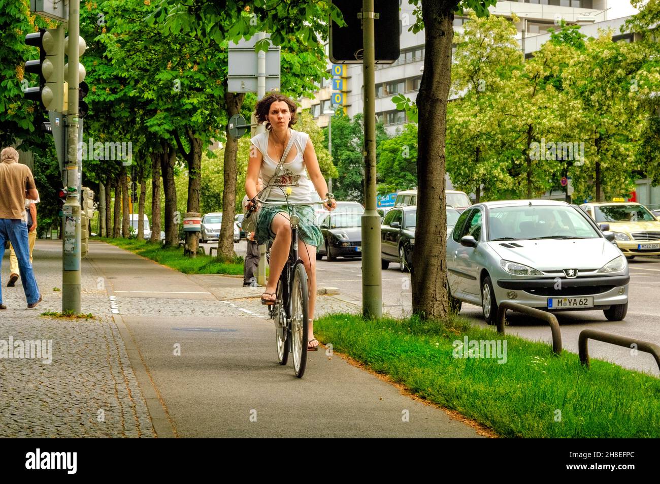 Women riding her bicycle through the streets of Munich Stock Photo