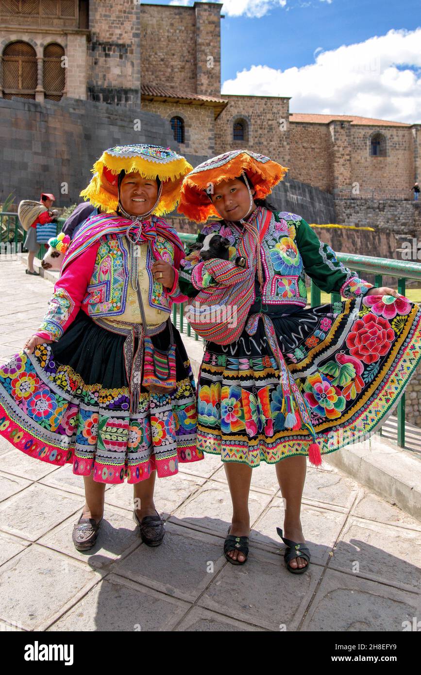 Quechua women wearing traditional clothing in front of the Qorikancha in Cusco Stock Photo