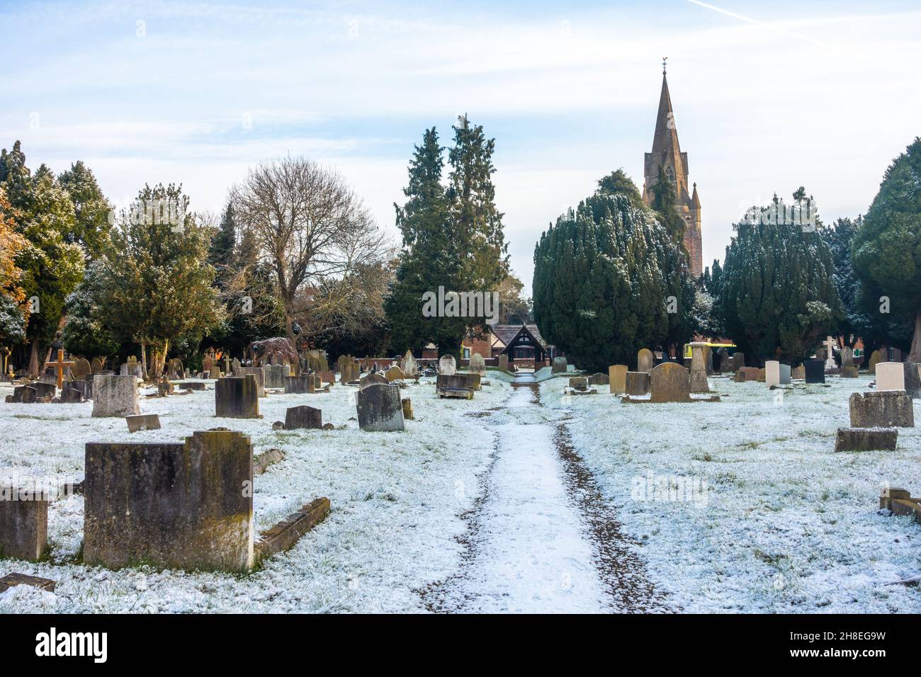 A view of the cemetery at St Michael's Church in Tilehurst Reading on a winter's day with a light covering of snow. Stock Photo