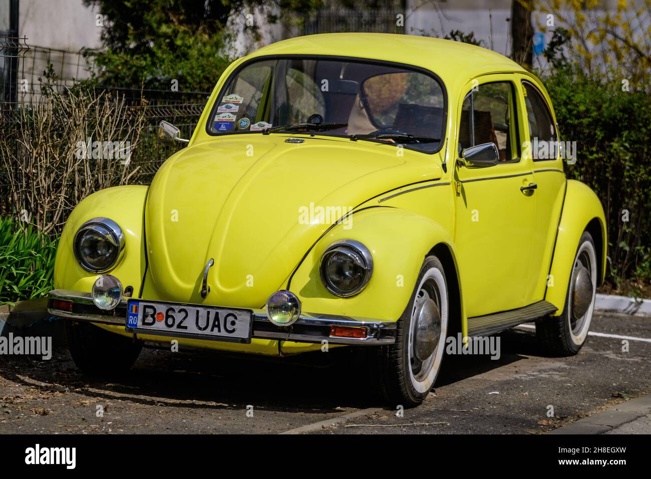 Bucharest, Romania, 2 April 2021 Old retro yellow Volkswagen Beetle classic car parked a street in a sunny spring day Stock Photo