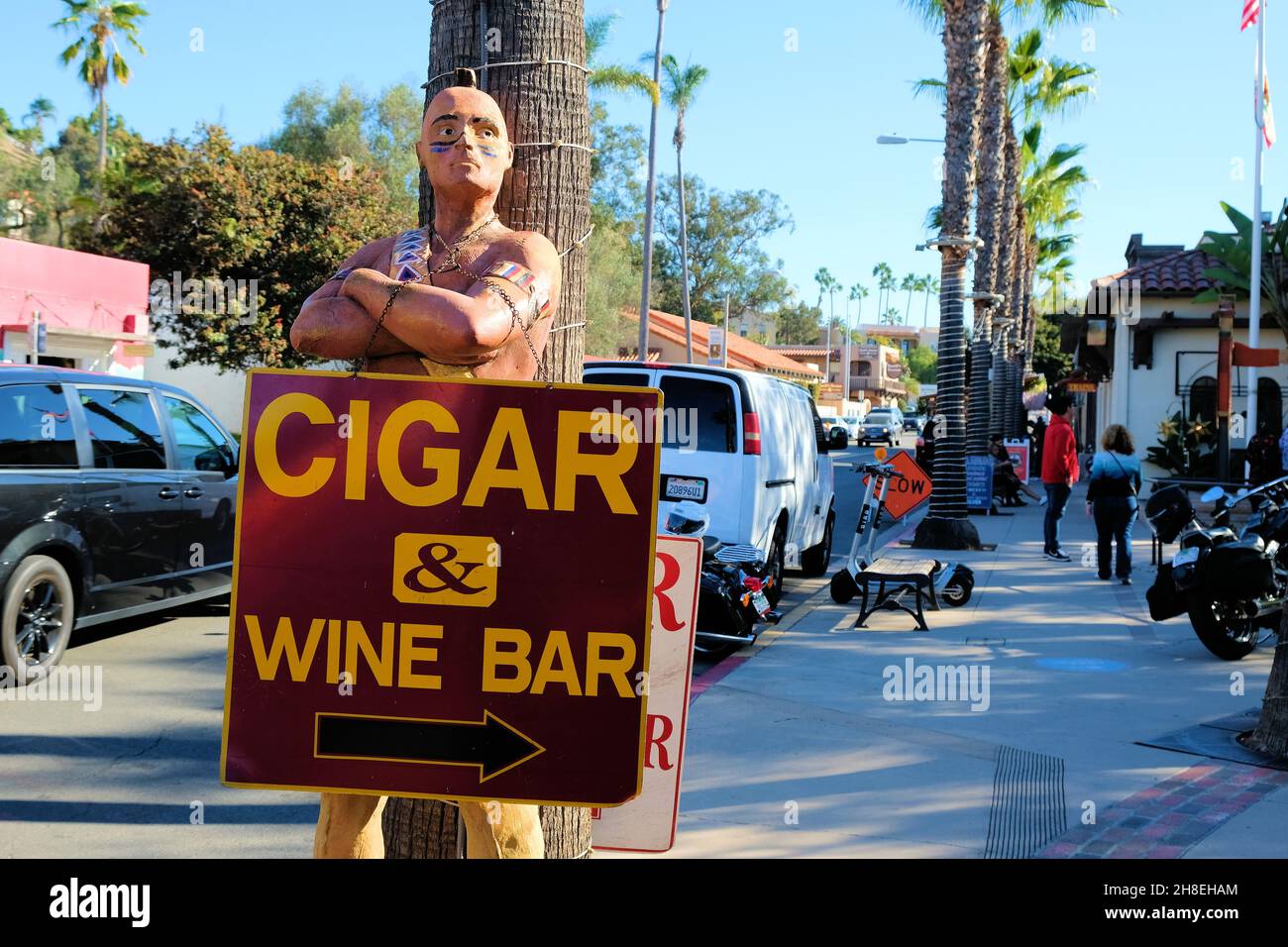 A Native American cigar store Indian on a sidewalk advertising a cigar