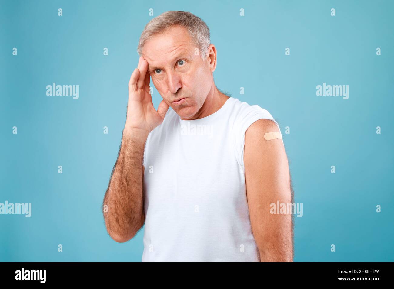 Side Effects To Vaccine. Man With Patch Suffering From Headache Stock Photo