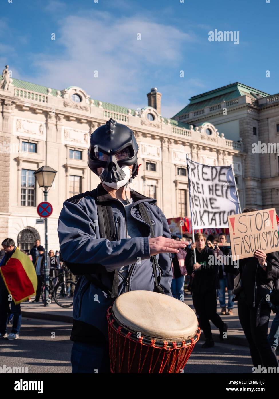 Vienna, Austria - November 20 2021: Masked Anti-Vax Covid-19 Demonstrator Drumming on Heldenplatz, Wearing a Stock Photo