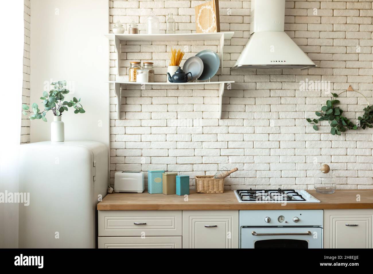 Modern Scandinavian kitchen interior with light furniture, household items near brick wall. Home decor concept Stock Photo